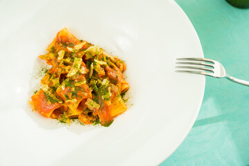 Tomato pasta with parmesan, basil and laurel oak close-up fork 