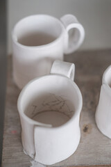 White handmade clay cups. Tea set on the table. White kitchen items