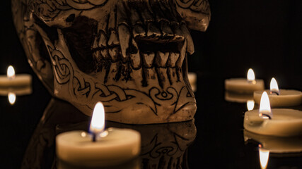 Teschio illuminato da candele con sfondo nero