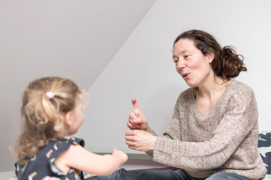 m&egrave;re et fille signe une comptine en LSF