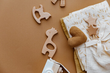 Wooden toys for kids, baby staff, newborn accessory on brown background. Set of gender neutral newborn accessories. Flat lay, top view - 415480845