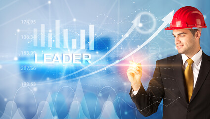 Young businessman with helmet drawing LEADER inscription, modern business technology concept