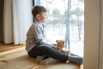 Boy sitting at the floor with his teddy bear
