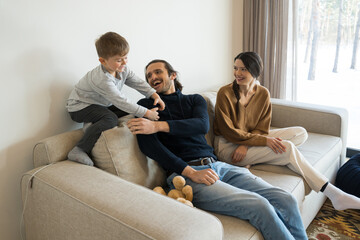 Boy playing in living room interior with parents