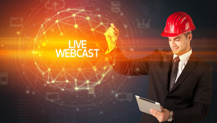 Handsome businessman with helmet drawing LIVE WEBCAST inscription, social construction concept