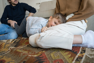 Son having fun while laying at the carpet with parents