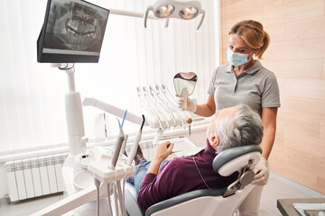 Dentist and patient looking at the results of whitening