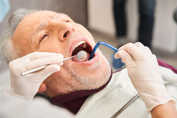 Dentist treating her patients teeth