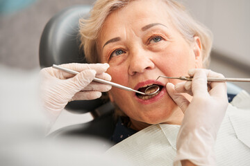 Woman is having her teeth examined by dentist