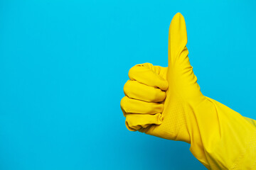 yellow glove for cleaning on womans arm show thumbs up