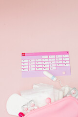 Fototapeta na wymiar Tampon, feminine, sanitary pads for critical days, feminine calendar, pain pills during menstruation on a pink background. Tracking the menstrual cycle and ovulation
