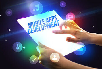 Holding futuristic tablet with MOBILE APPS DEVELOPMENT inscription, new technology concept
