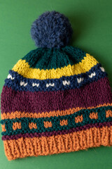 colourful hand knit pompom hat using fair isle knitting technique 