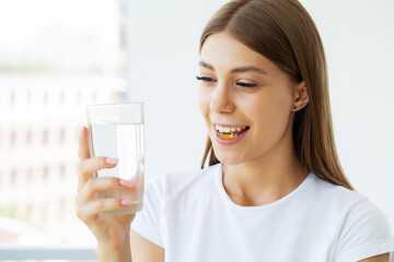 Portrait of smiling young woman with Omega 3 fish oil capsule