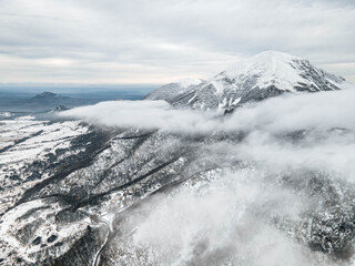 Mountain peak in the snow against the backdrop of low clouds. Location Pyatigorsk, Mount Beshtau