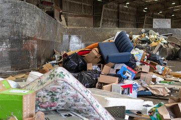 Piles of refuse and garbage in a solid waste station or dump including mattresses, chairs and...