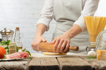 Chef prepares dough in a light kitchen with ingredients, culinary recipes, cooking bread, baking italian pasta.Restaurant and hotel business, horizontal photo, menu