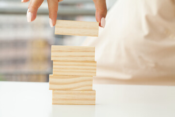 Hand putting and stacking blank wooden cubes on table with copy space for input wording and infographic icon.