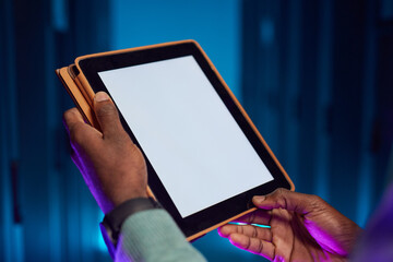 Closeup of African American data engineer holding digital tablet with blank white screen while...