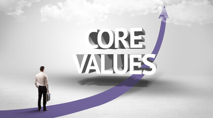 Rear view of a businessman standing in front of CORE VALUES inscription, successful business concept