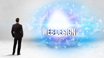Rear view of a businessman standing in front of WEB DESIGN inscription, modern technology concept