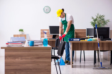 Young male contractor cleaning the office