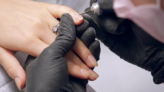 Manicure process. Correction of female nails with drilling machine