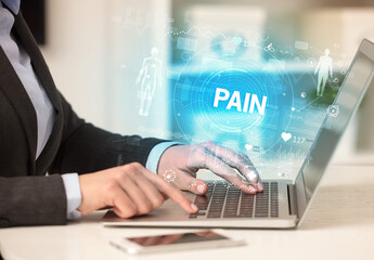 Doctor working a health check with PAIN inscription, recording medical test results