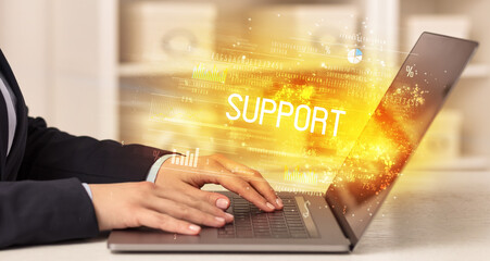 Closeup of businessman hands working on laptop with SUPPORT inscription, succesfull business concept