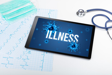 Tablet pc and doctor tools on white surface with ILLNESS inscription, pandemic concept