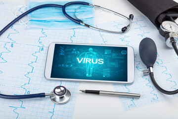 Tablet pc and doctor tools with VIRUS inscription, coronavirus concept