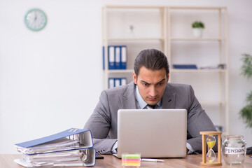 Young male employee in pension concept at workplace