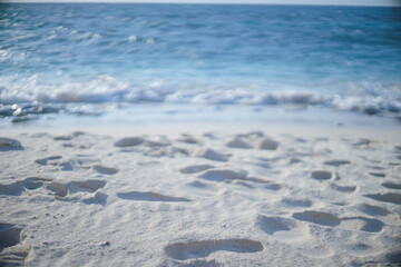 沖縄県の離島宮古島の青い海の波打ち際と砂浜の足跡