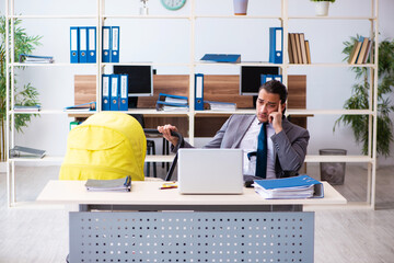 Young male employee looking after newborn at workplace