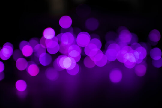 Bright purple bokeh lights on black background