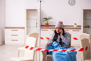Young sick man suffering at home in pandemic concept