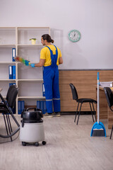 Young male contractor cleaning the office