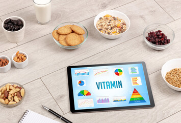 Organic food and tablet pc showing VITAMIN inscription, healthy nutrition composition