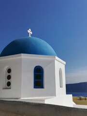 Fototapeta na wymiar Cúpula y domos en calles de Santorini, Grecia. Cielo azul