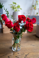 a bouquet of roses in a glass vase with other stems