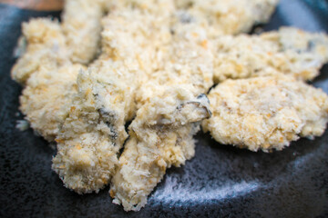 パン粉に包まれた調理前のカキフライ
