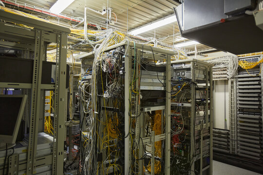 Wide angle background image of server room network with internet cables and wires in heaps, copy