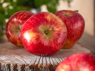 Large red apples close-up on a wooden unpainted board against