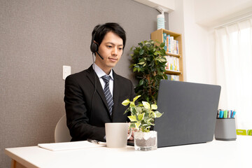 Young man in a teleworking suit, Asian man with remote working headphones, black hair