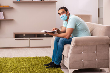 Young male student studying at home during pandemic