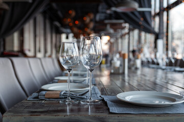 Modern veranda restaurant interior, banquet setting, glasses, plates
