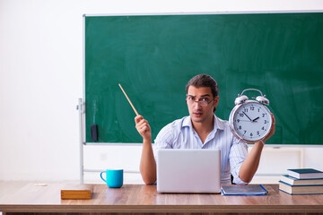 Young male teacher in time management concept