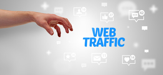 Close-Up of cropped hand pointing at WEB TRAFFIC inscription, social networking concept