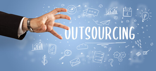 Close-Up of cropped hand pointing at OUTSOURCING inscription, modern business solution concept
