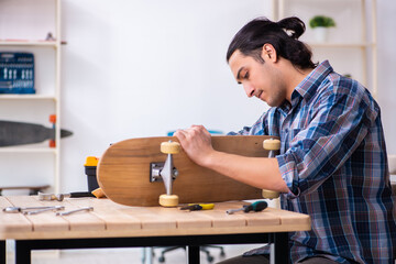 Young man repairing skateboard at workshop